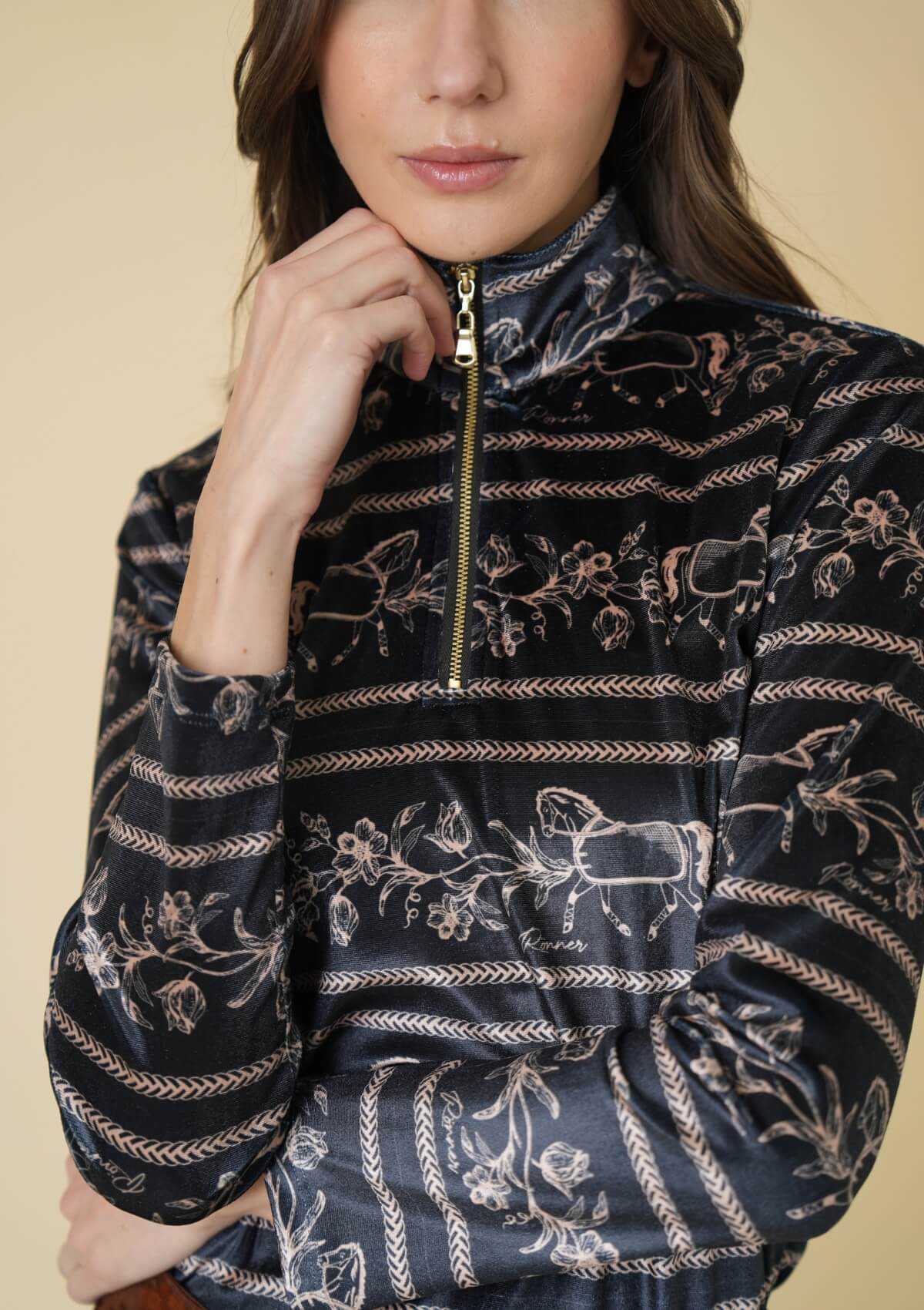 Woman wearing a black patterned jacket with a beige background
