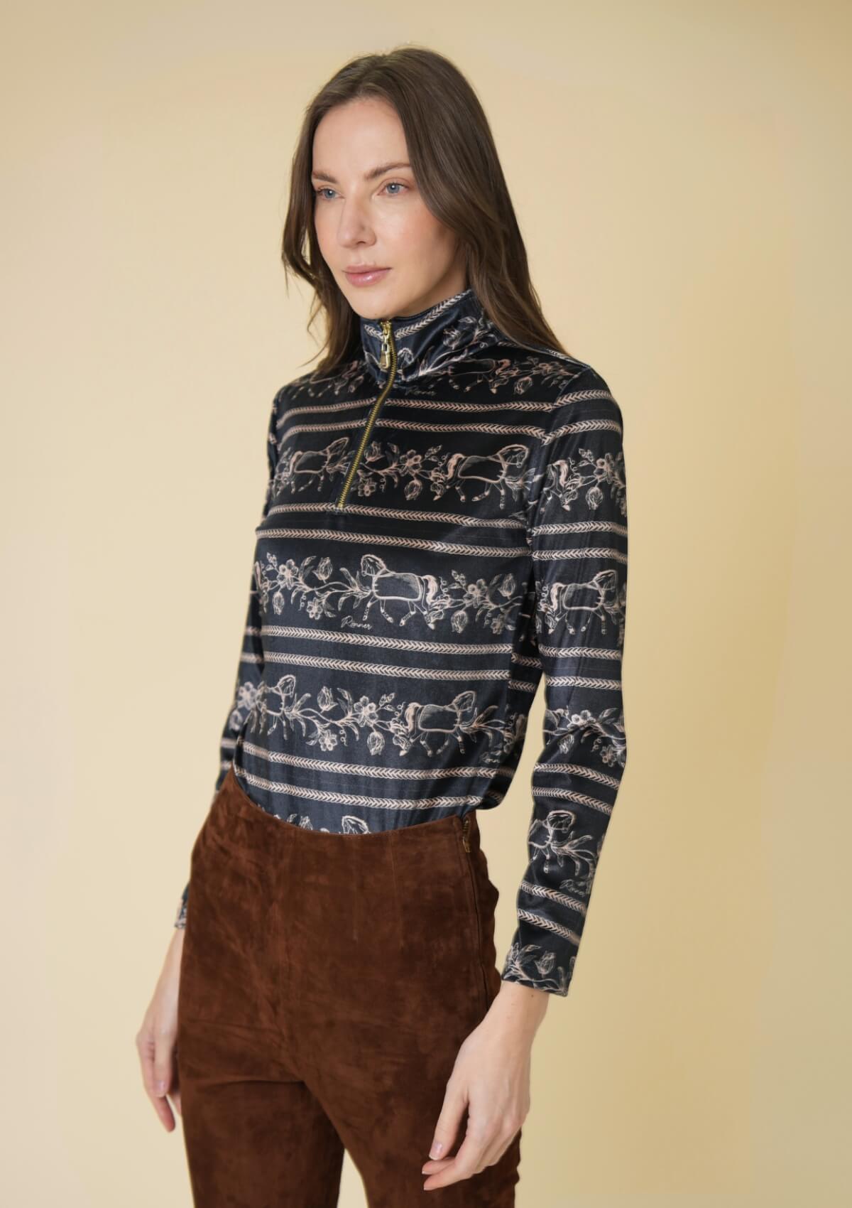 Woman wearing a patterned and brown pants against a beige background